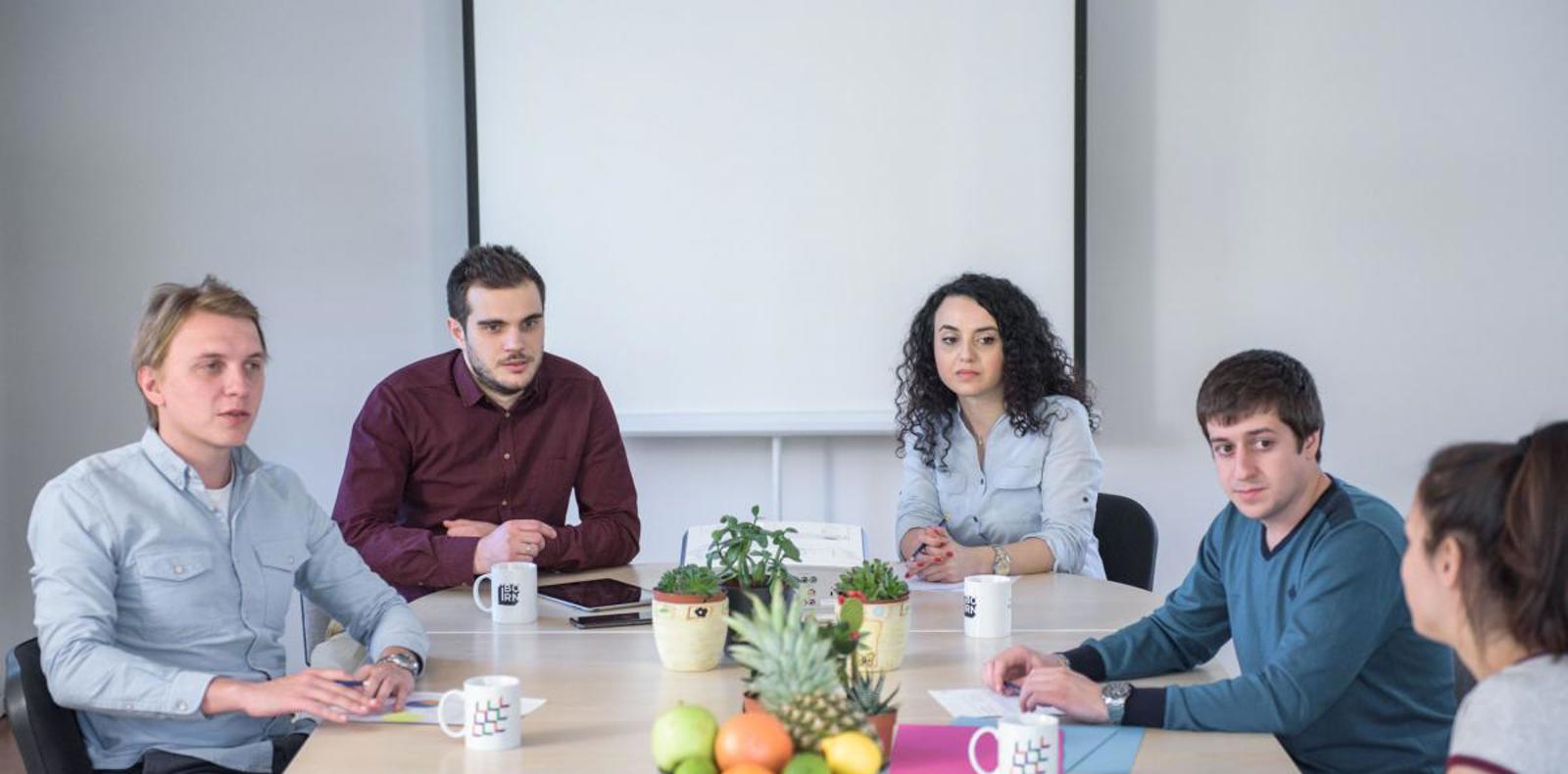 A diverse group of professionals discussing ideas and collaborating in a meeting room.