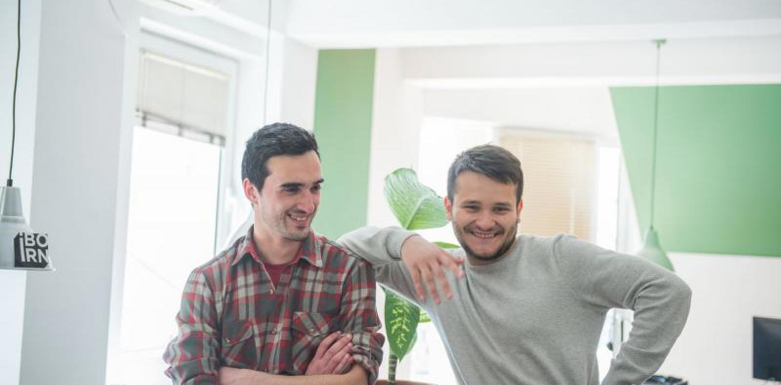 Two colleagues posing and smiling at the camera.