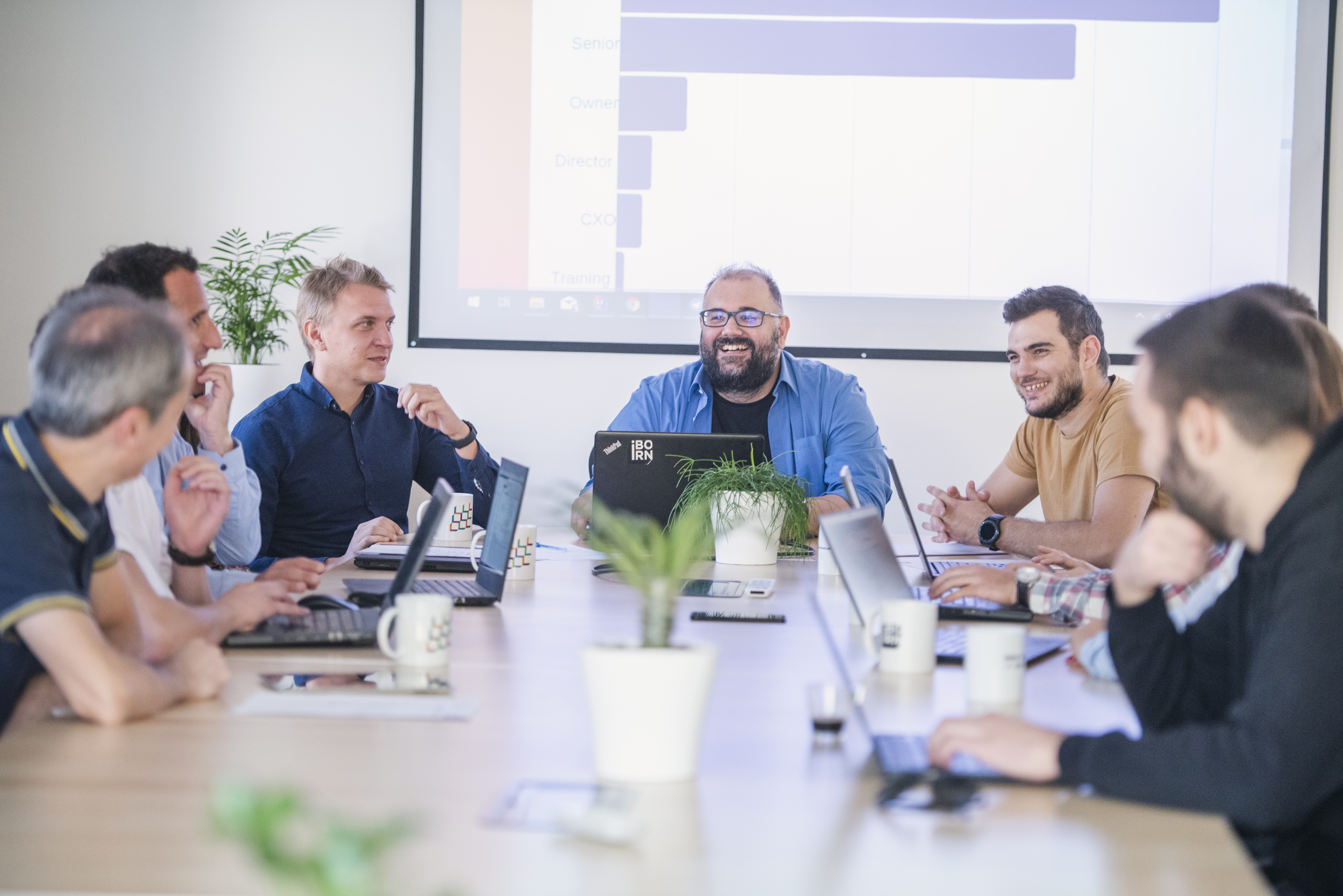 Team of people using laptops during a meeting.