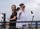 Women on a balcony, capturing a moment with a spin camera.

