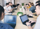 A diverse group of individuals sitting around a table, engrossed in their work on laptops.