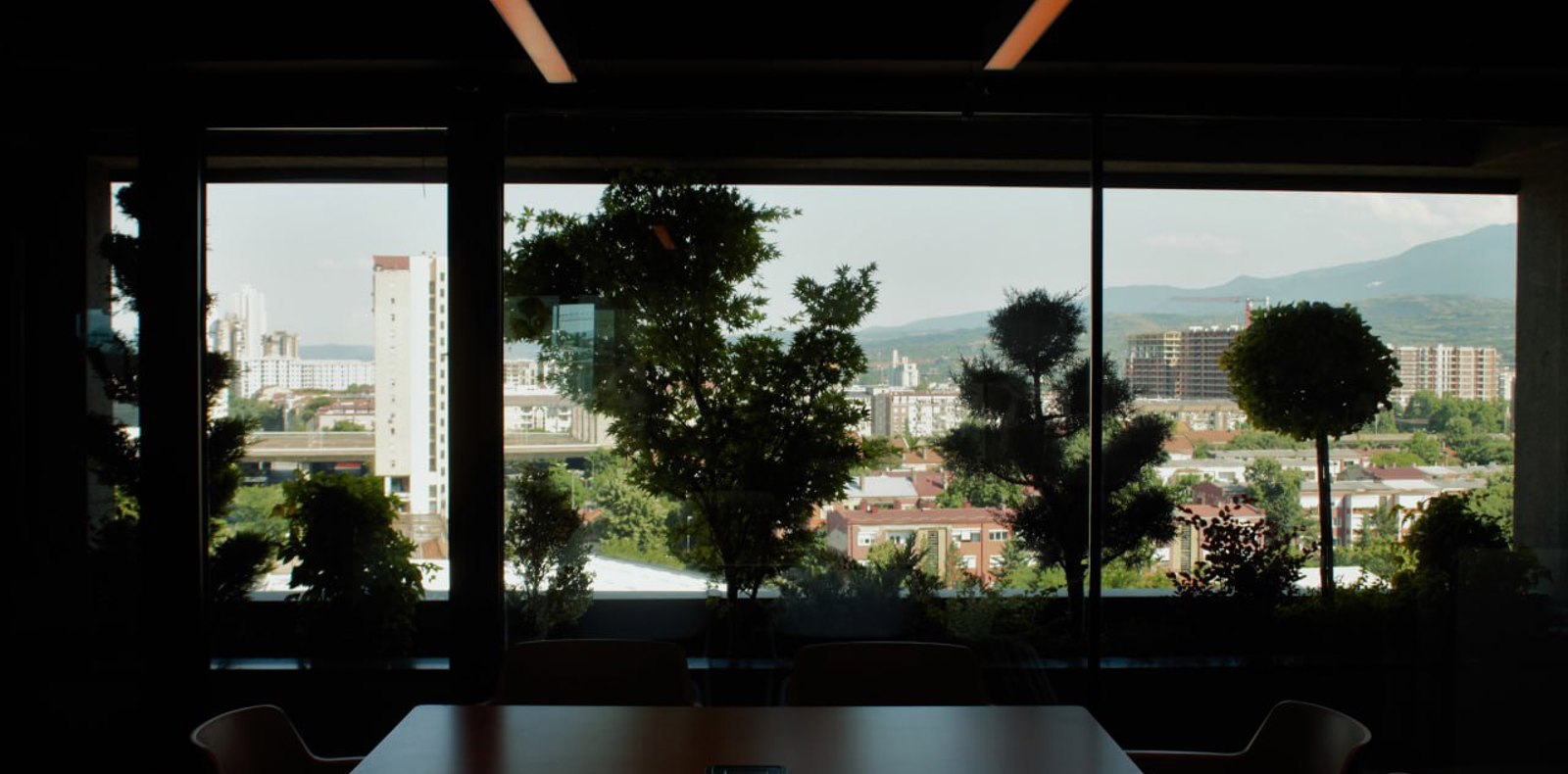 A table with chairs placed in front of a window, offering a serene view of the outside world.