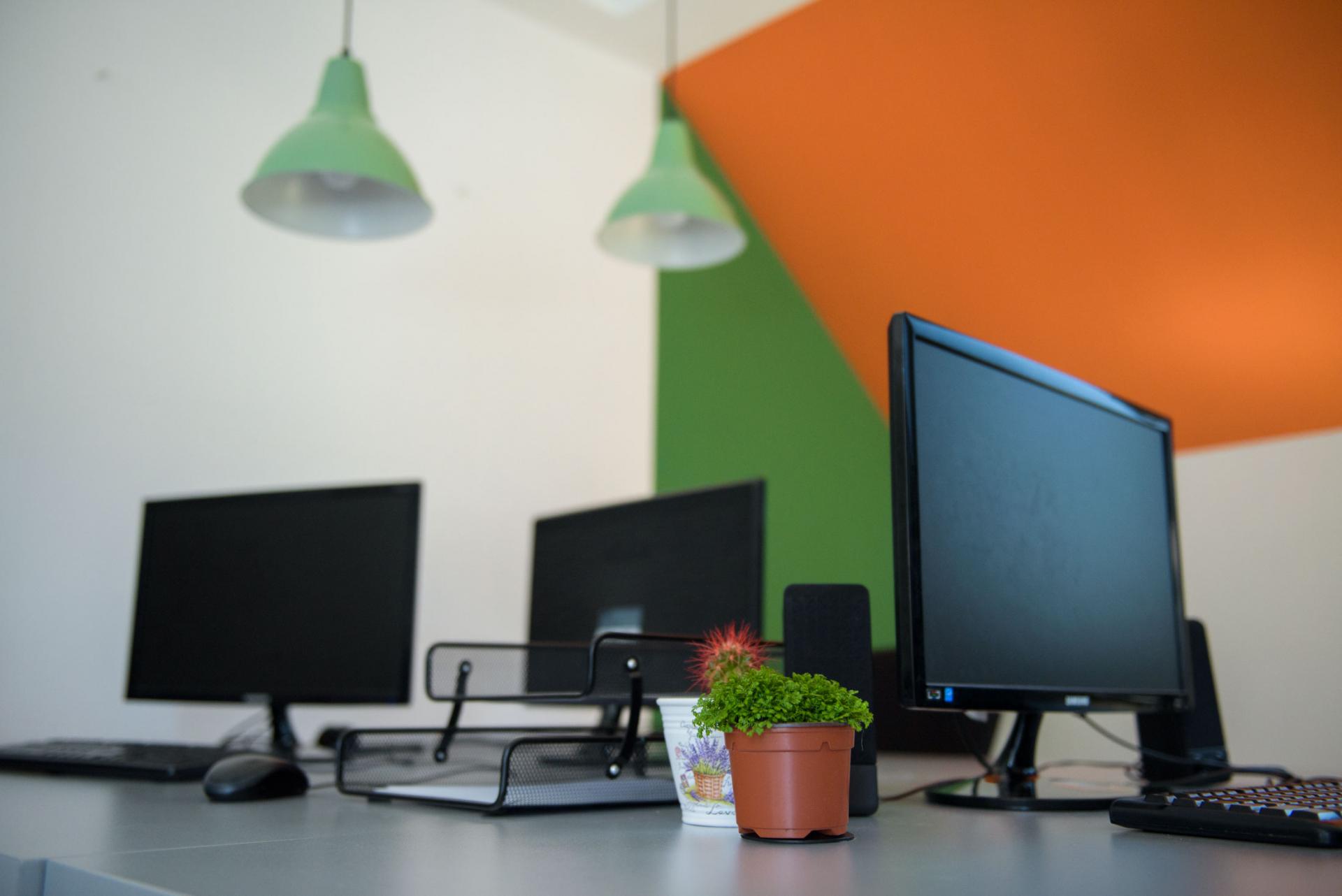 Three computer monitors neatly arranged on a desk.