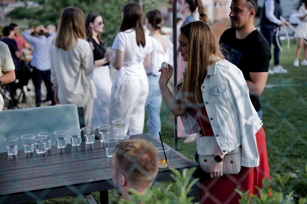 A woman playing beer pong on a sunny picnic party
