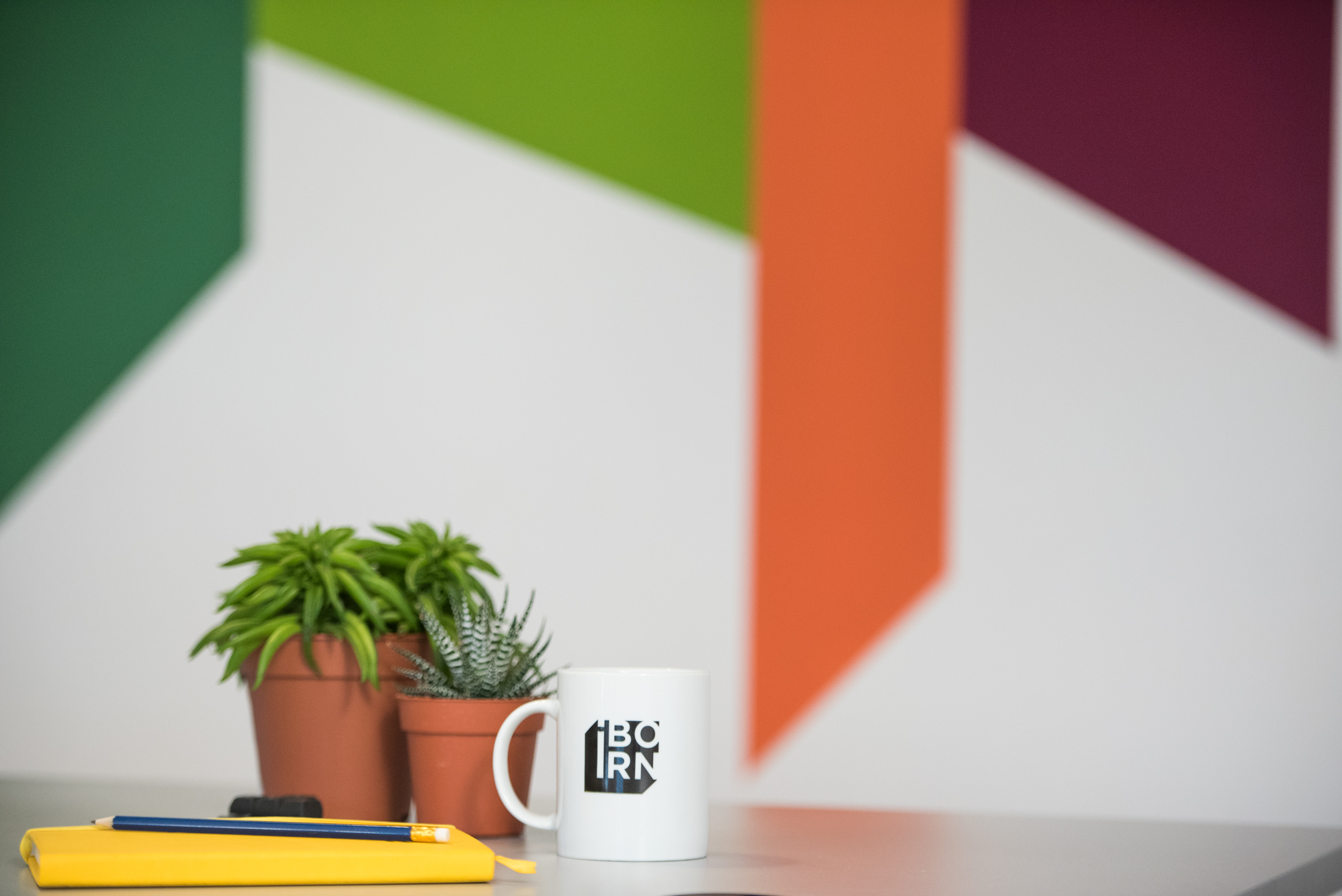 A coffee mug, notebook, and pencil neatly arranged on a desk.
