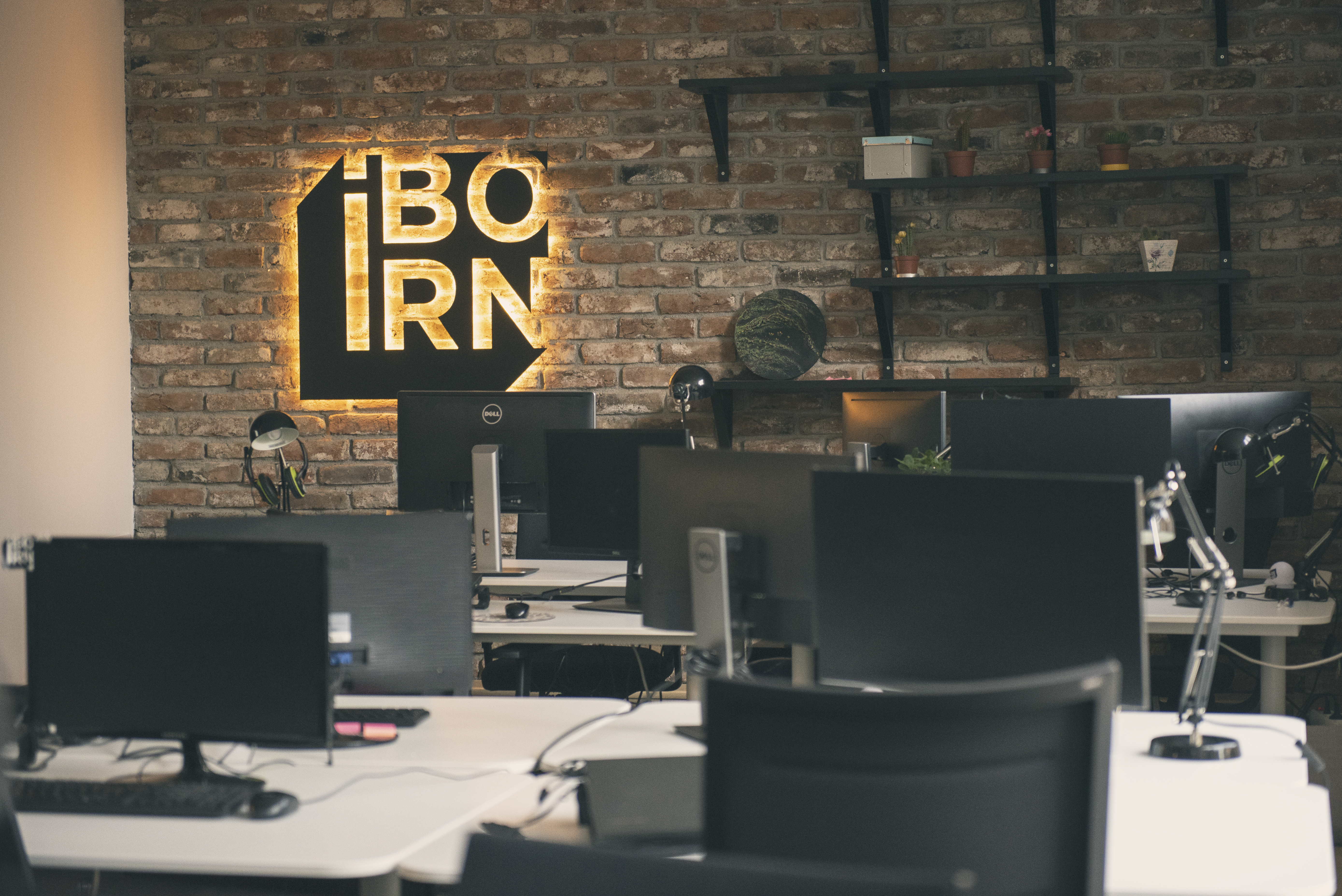 A modern office environment with the IBORN logo on the wall.