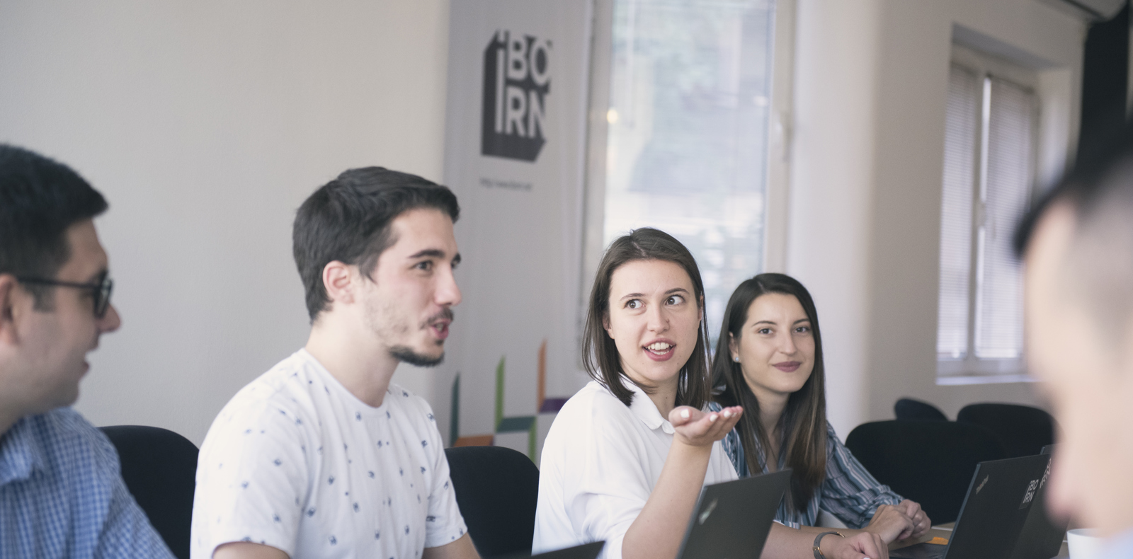 Colleagues discussing work on a meeting in a conference room.