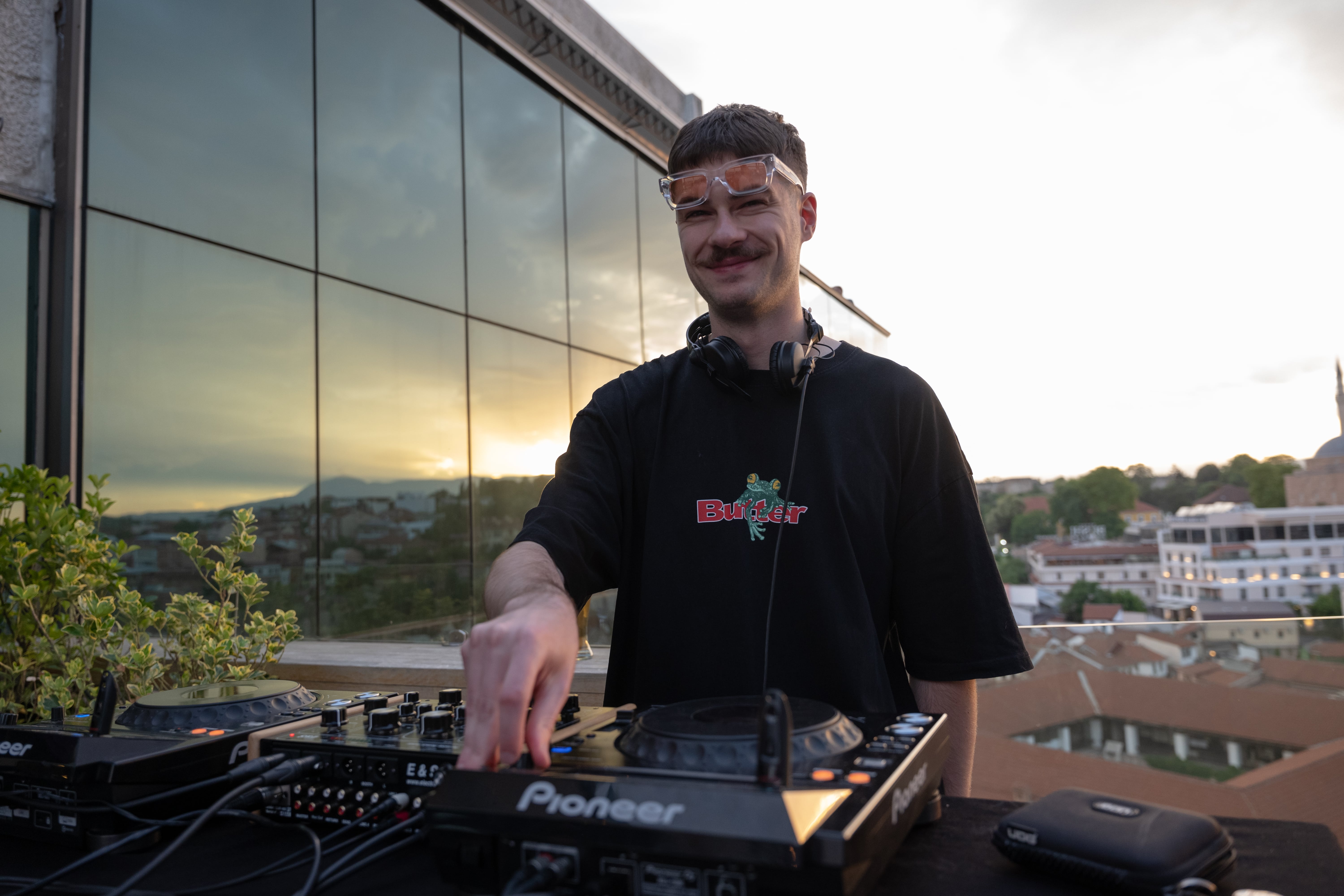 DJ in black shirt creating music on mixer.