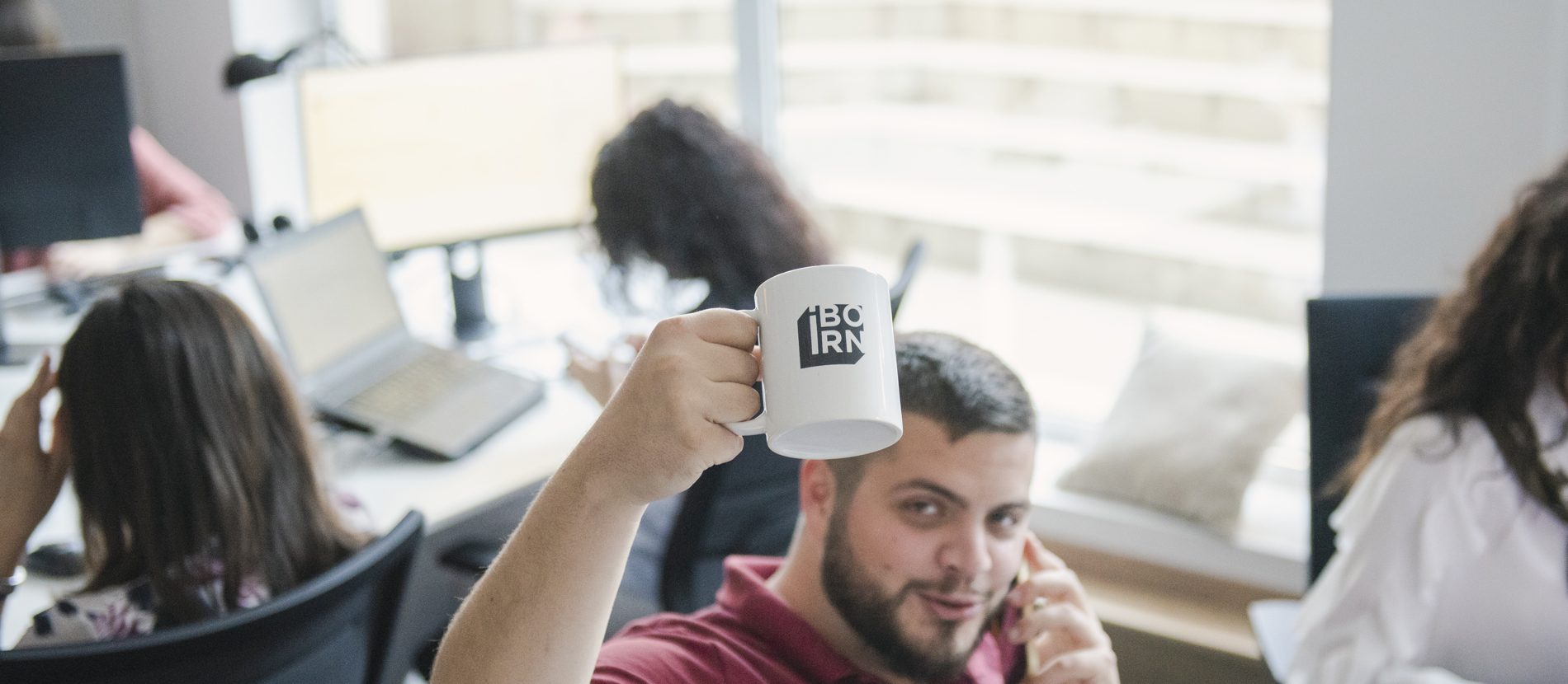 Two people working on computers at a desk.