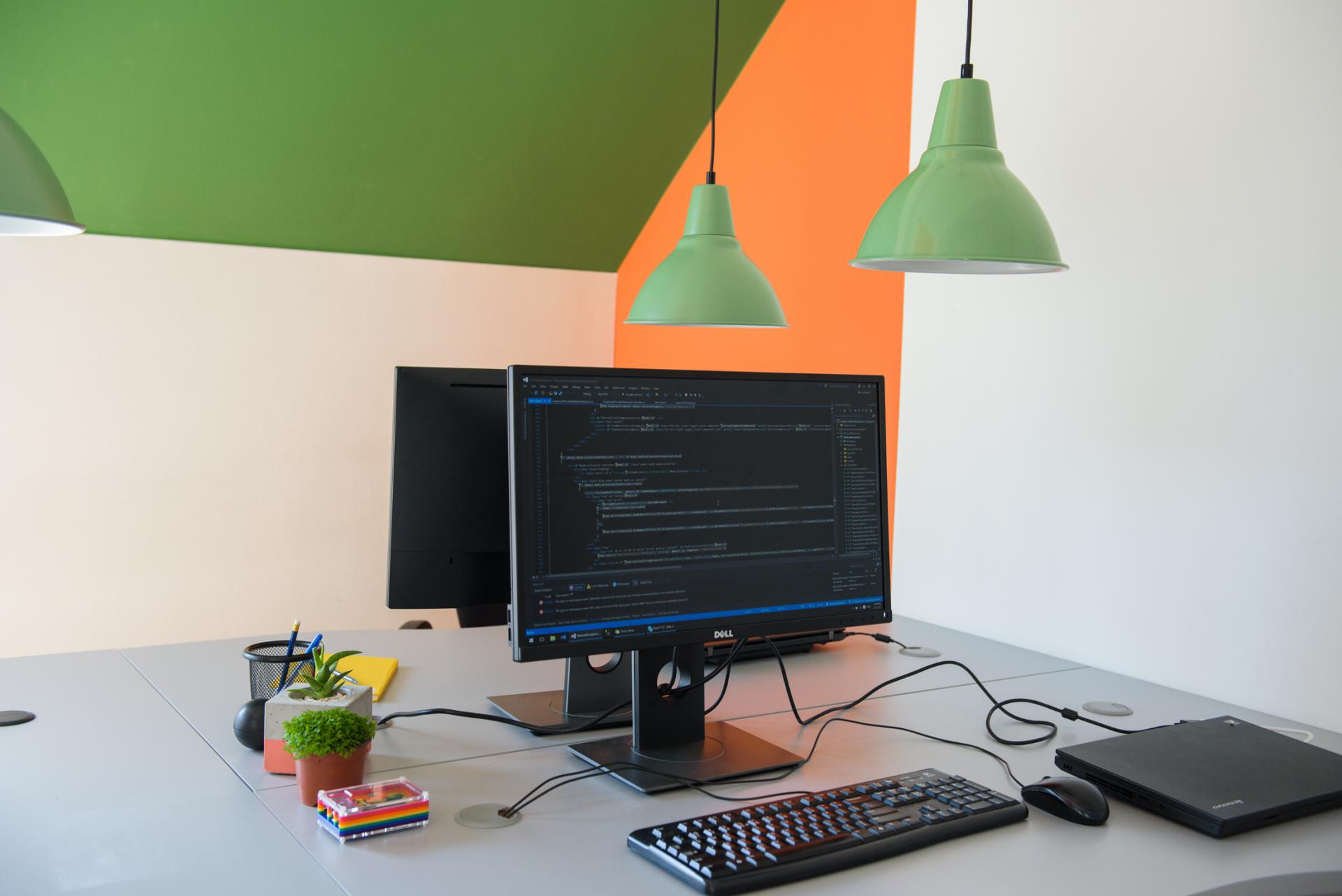 A modern computer desk with dual monitors and a keyboard, providing a productive workspace.