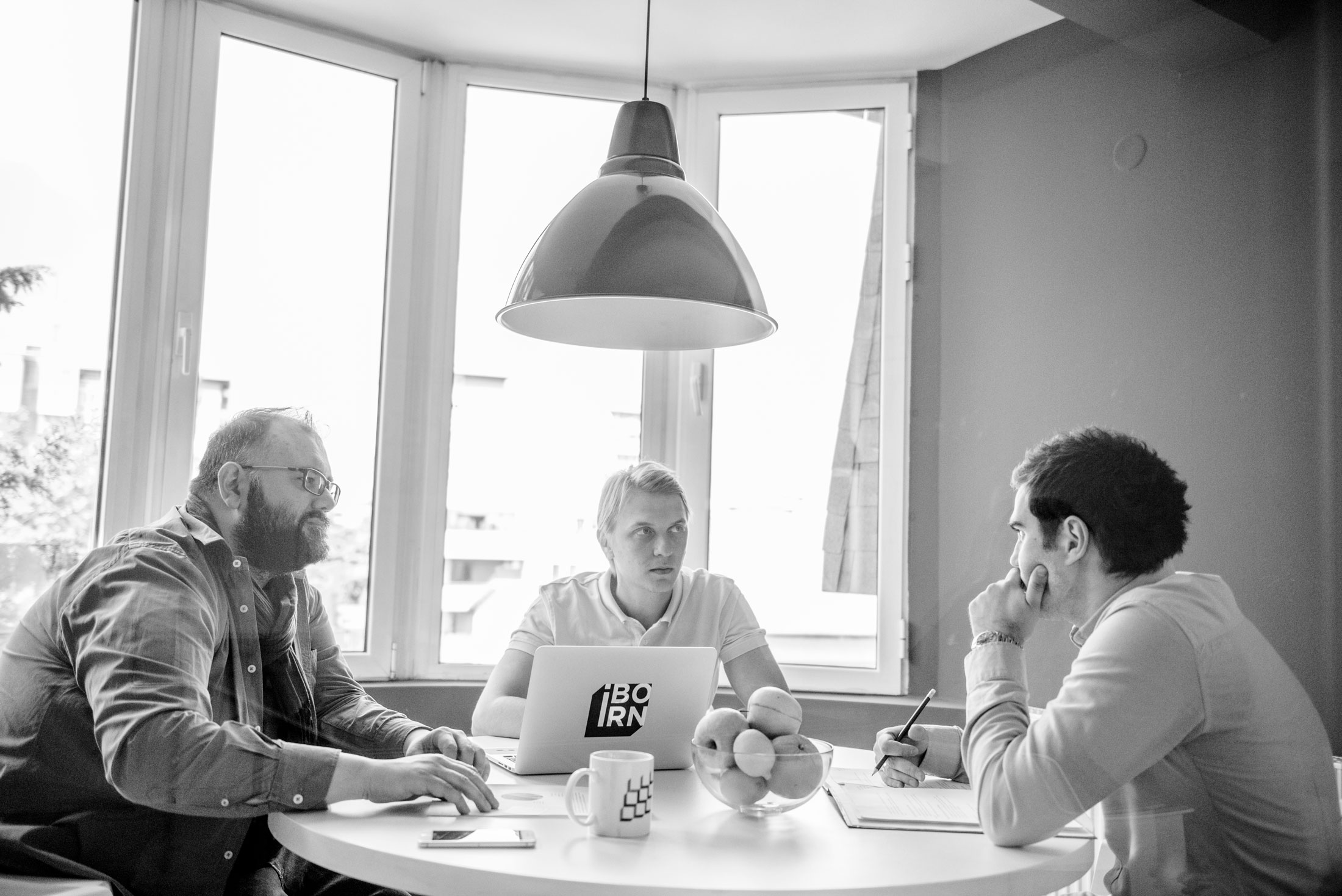 Three people sitting on a table and discussing work. 