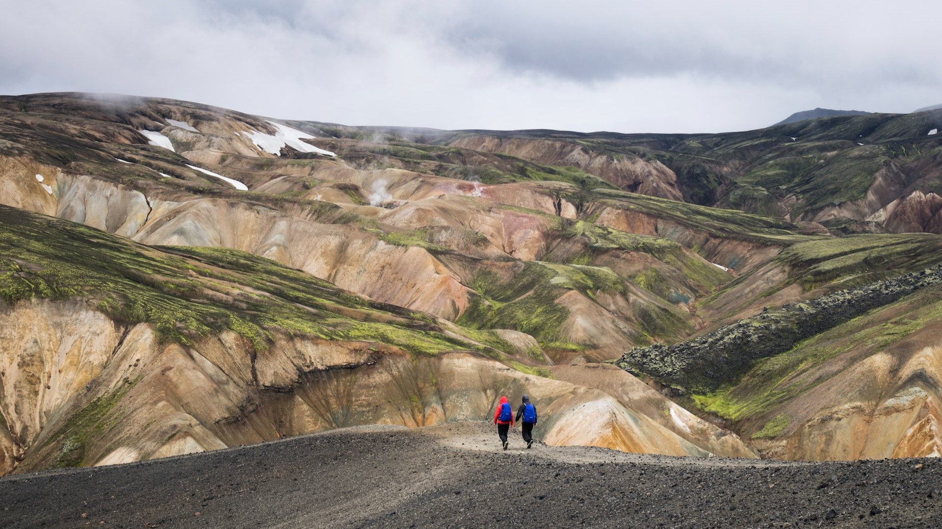 Two hikers ascending a snowy Icelandic mountain.