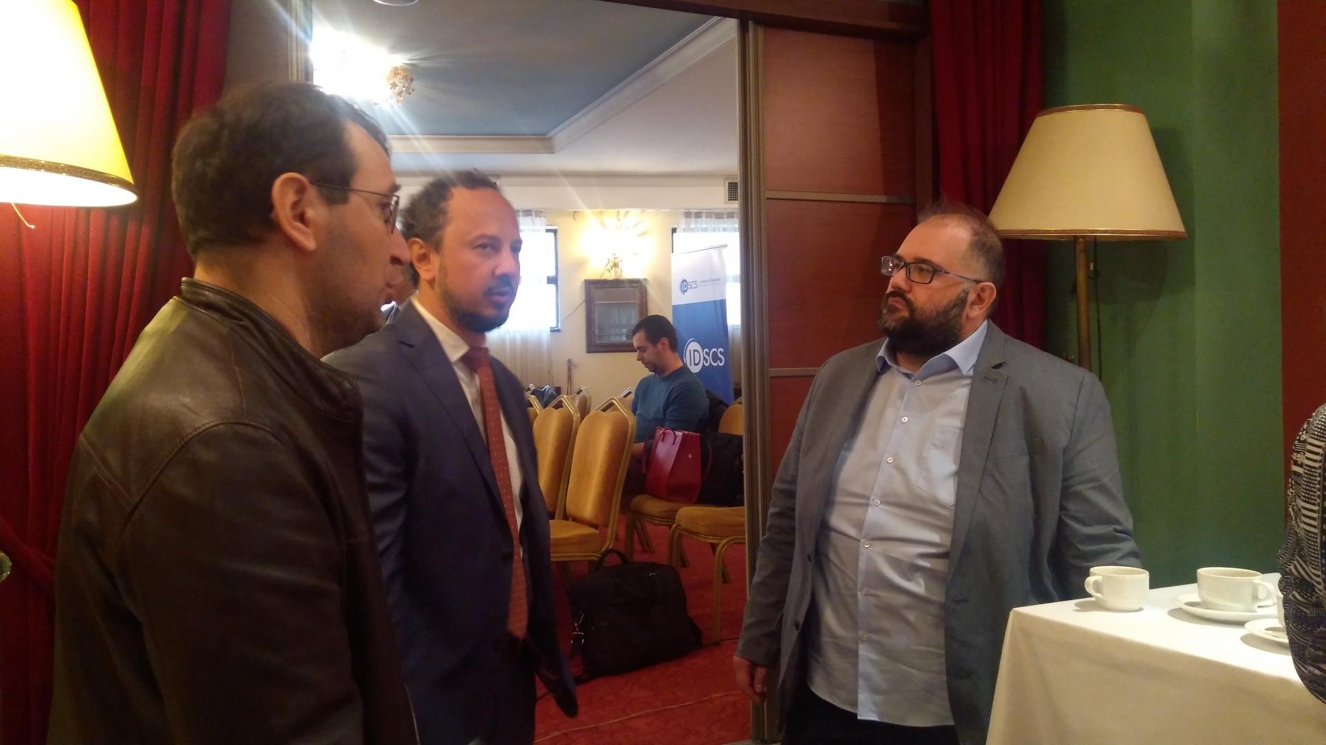 Three men discussing.