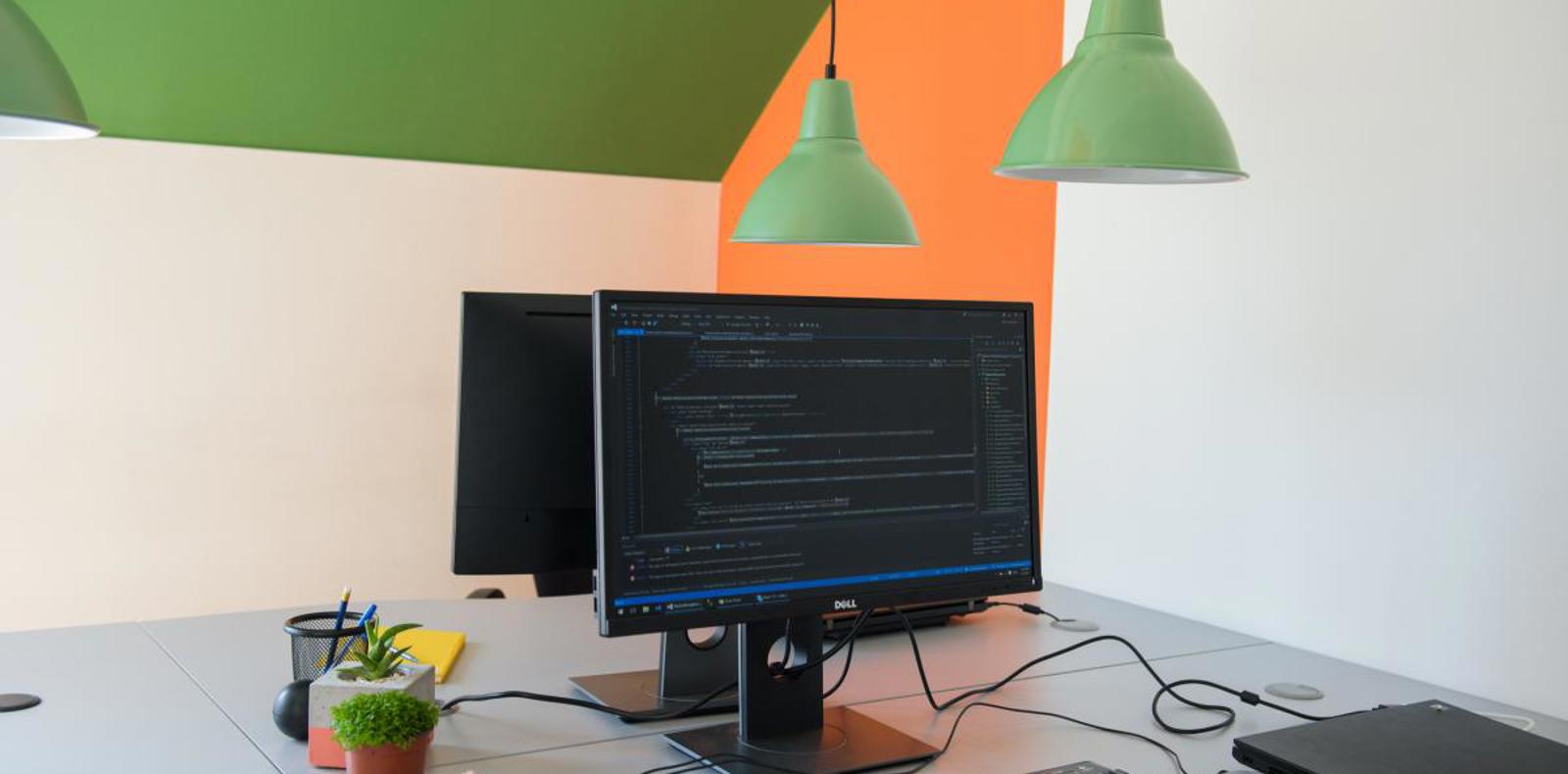 A computer with a keyboard and monitor on a desk.