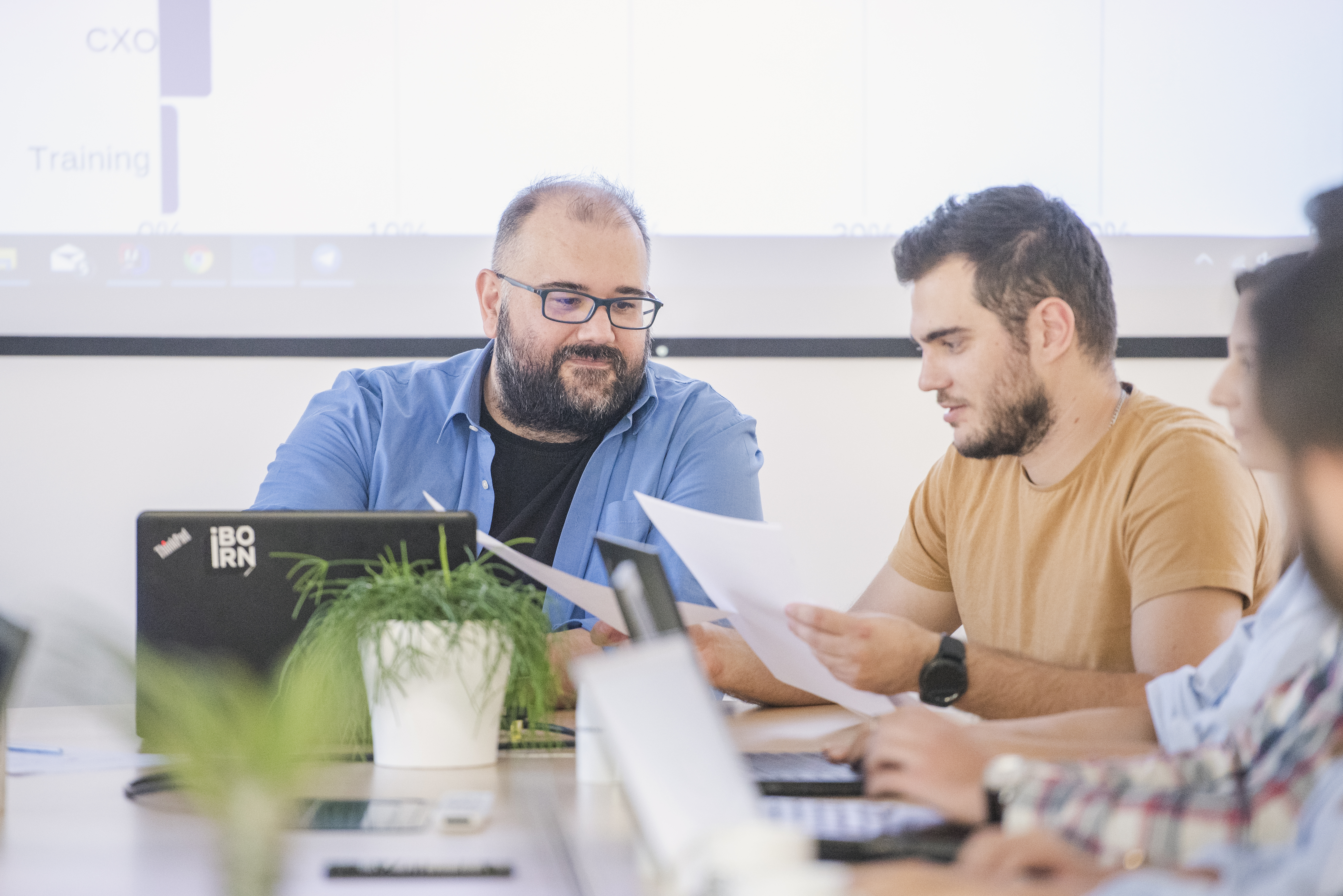 Mobile developers planning and working together in a bright conference room.