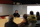 A team of people gathered around a table, actively participating in a meeting, with a whiteboard illustrating their discussion points.