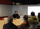 A team of people gathered around a table, actively participating in a meeting, with a whiteboard illustrating their discussion points.
