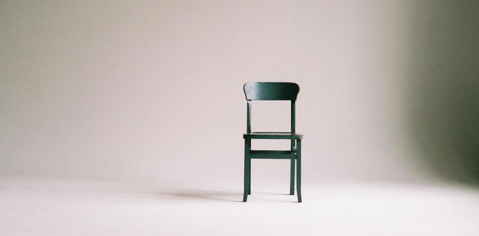 Black wooden chair in a well-lit room with a bright background.


