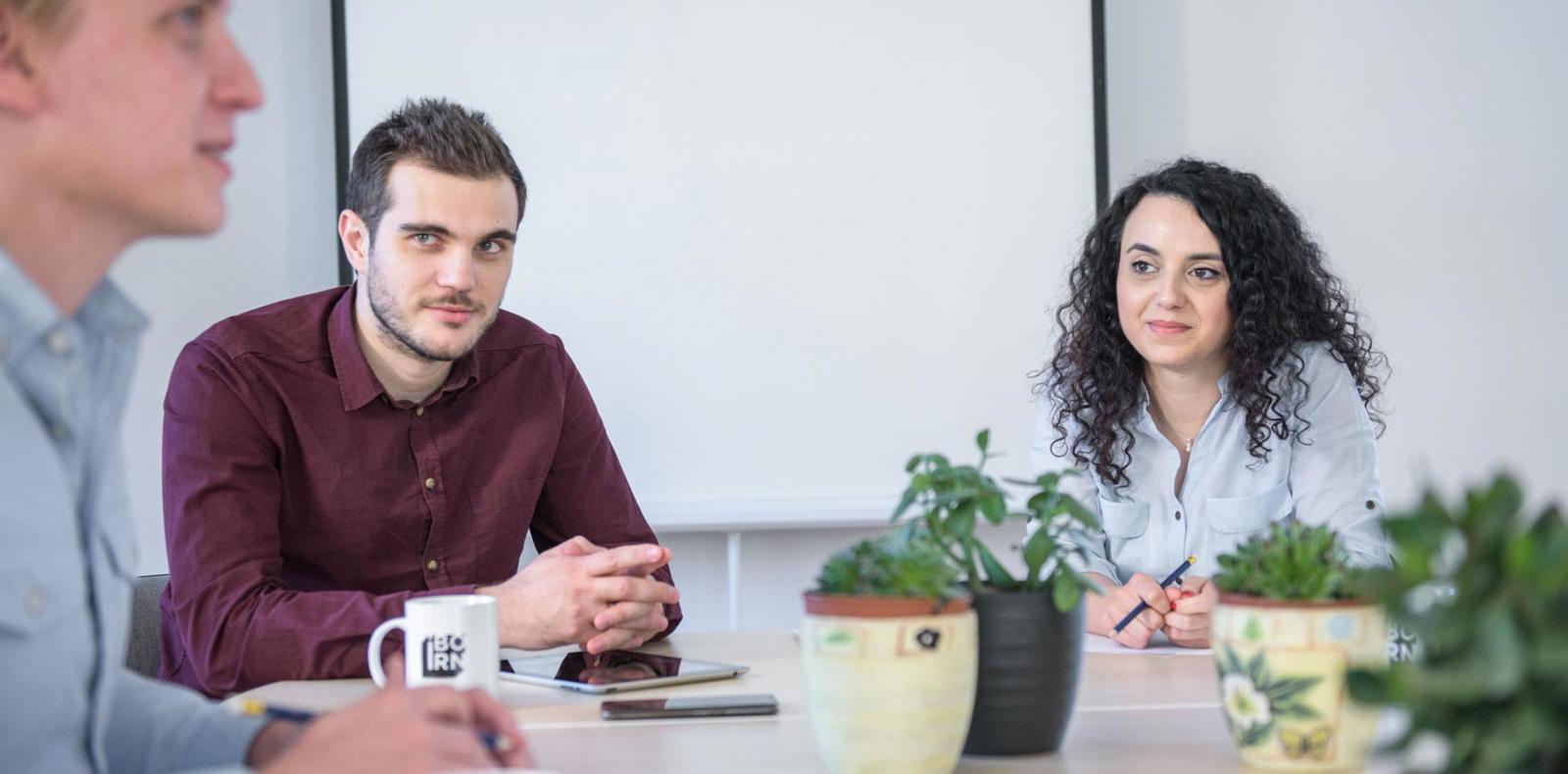 Group of individuals having a meeting at a table in a conference room.