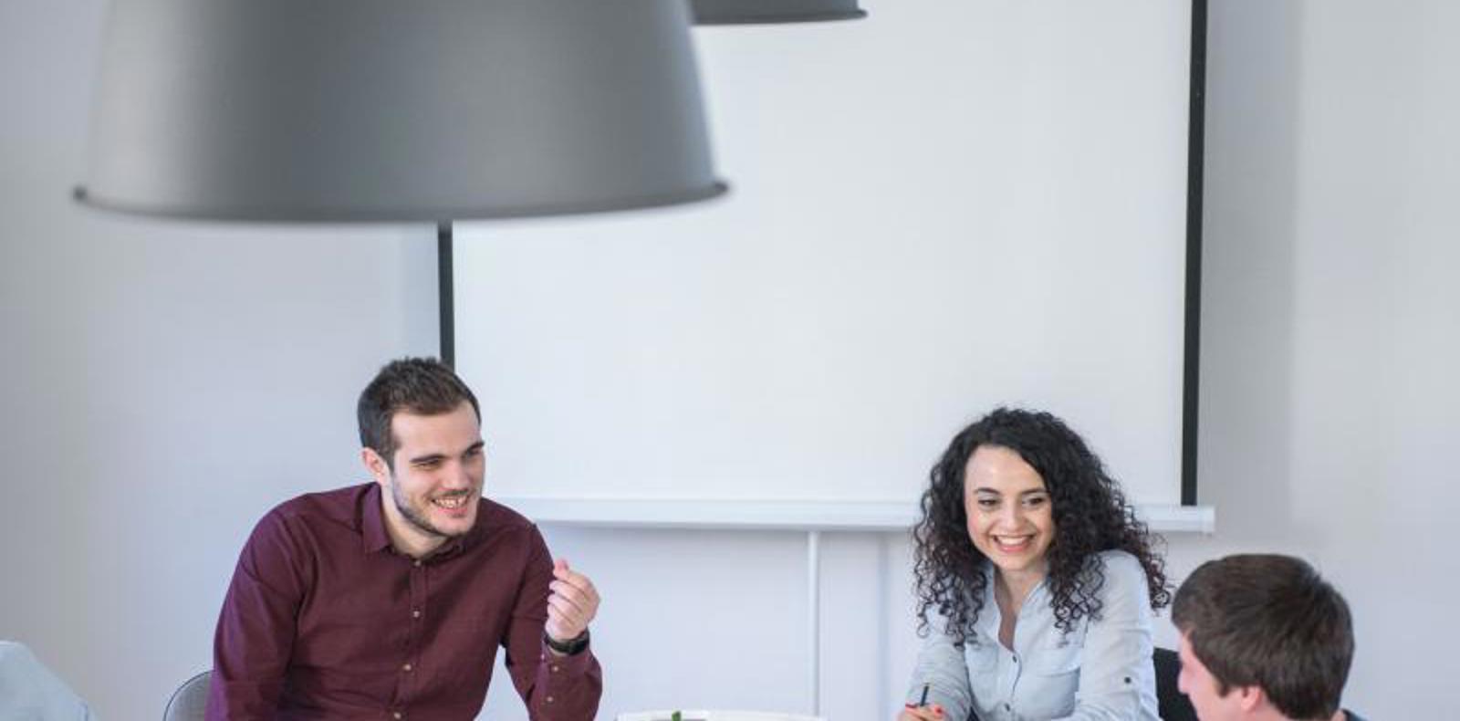 A group of software engineers engaged in a productive discussion at a conference table in an office setting.