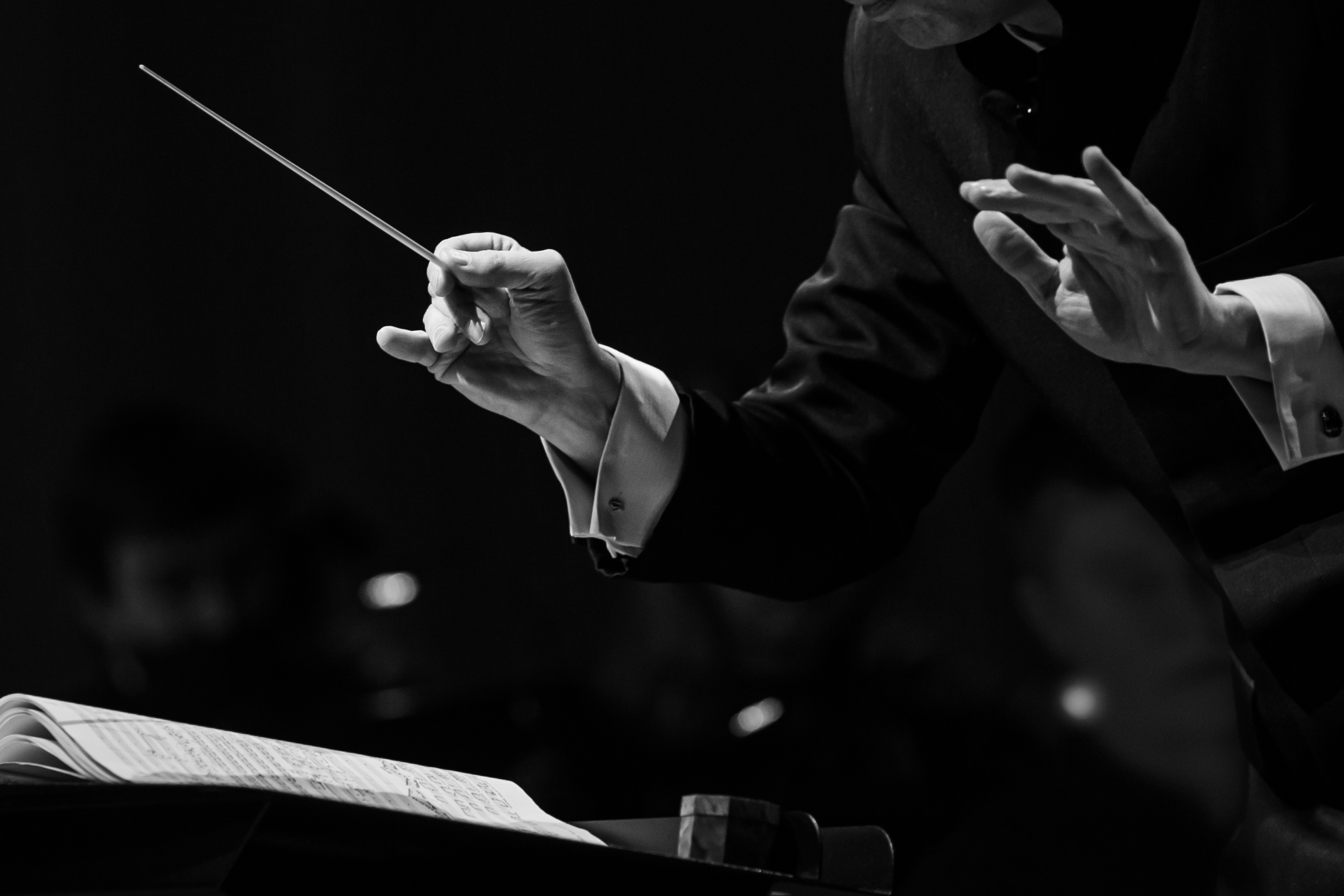 Orchestra conductor directing with a baton, a visual metaphor for multi-agent AI orchestration