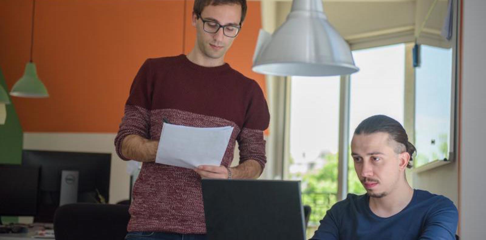 Two colleagues working together in a modern office environment. 