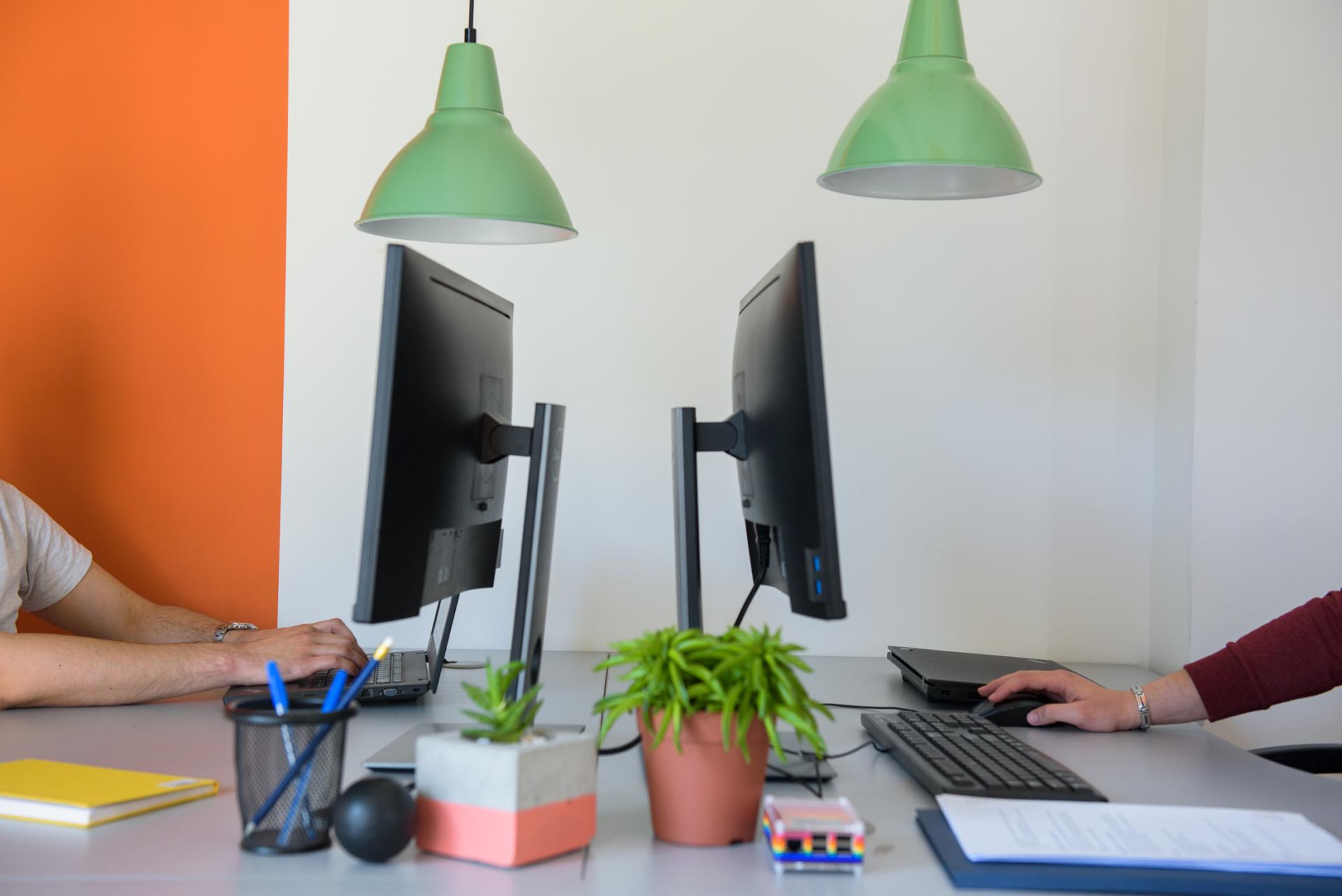 Two people working on computers at a desk.