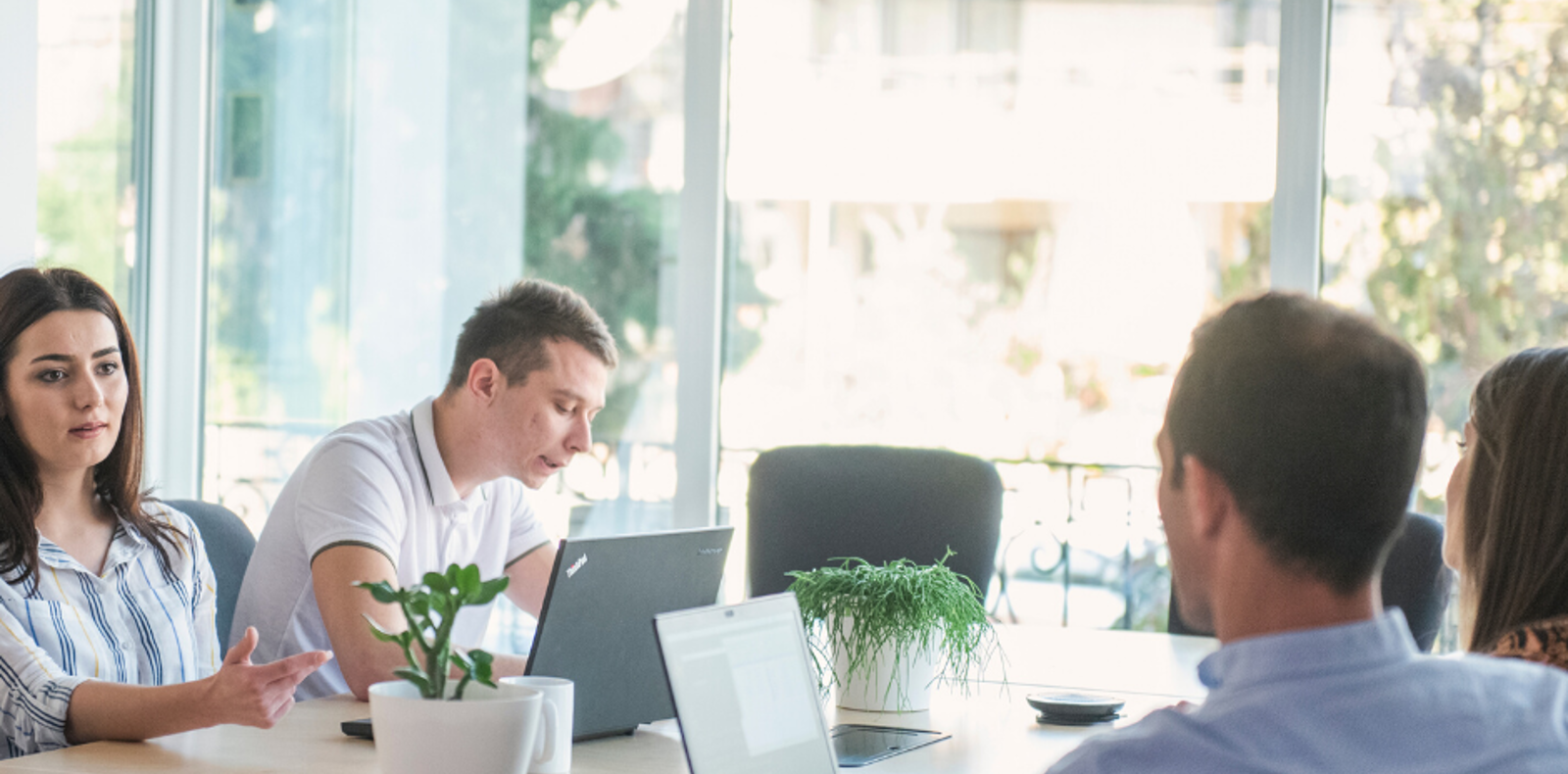 four people having a meeting in a conference room.