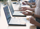 Several people sitting at a table with laptops, working together on a project.